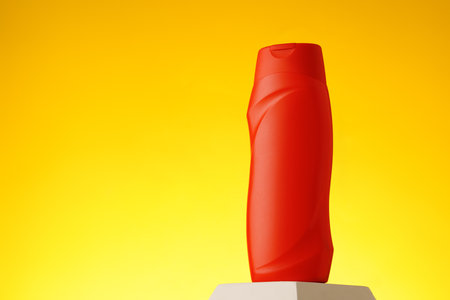 Cosmetic bottle with sunscreen lotion on yellow backgroundの写真素材