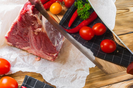 Raw T-bone steak with herbs on wooden board