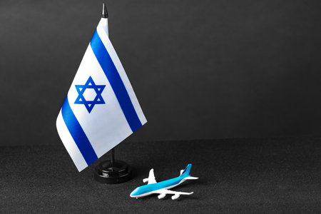 Small flag of Israel and toy plane on black backgroundの写真素材