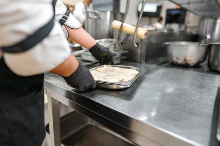 Chef cooking food at restaurant kitchen close upの写真素材