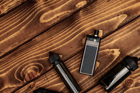 Vape and vape juice bottles on brown wooden backgroundの写真素材