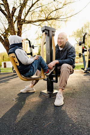 Happy father with his son spending time together on a sports ground