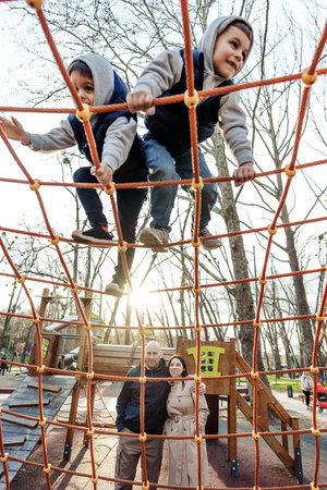 Two cute boys brothers playing on a playground outdoorsの写真素材