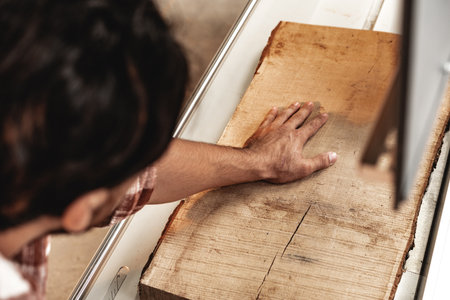 Close-up of carpenters hands working with wood piece in a workshopの写真素材
