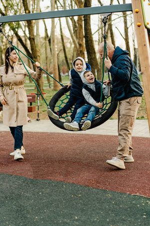 Happy couple with two kids boys on a playground