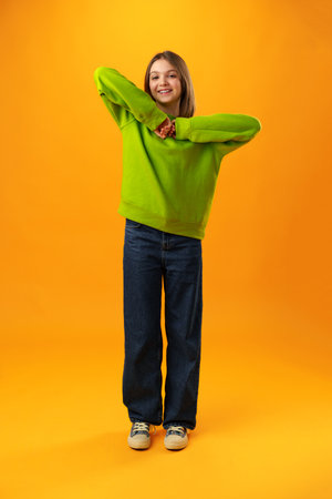 Photo of teen girl smiling portrait against yellow background in studioの写真素材