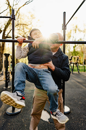 Happy father with his son spending time together on a sports ground