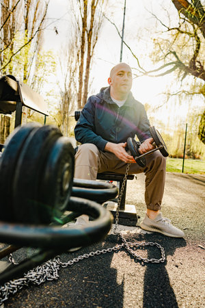Young bald man on sports ground in the parkの写真素材