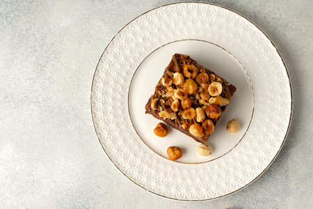 Brownie cake with nuts topping on plate close upの写真素材