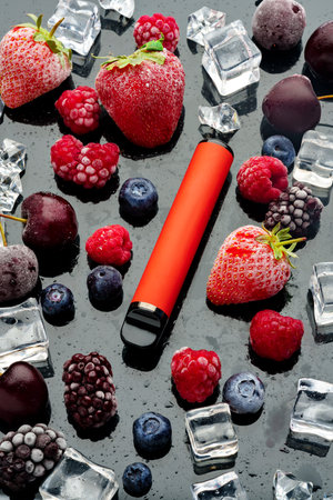 Electronic cigarette with berries and ice cubes on black backgroundの写真素材