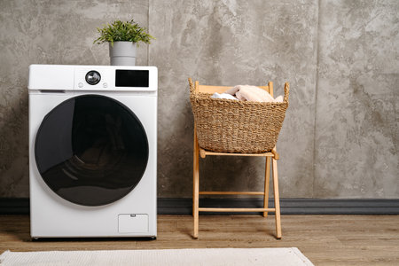 Laundry room interior with washing machine near gray grunge wall