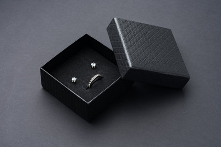 Open jewelry box on black paper background