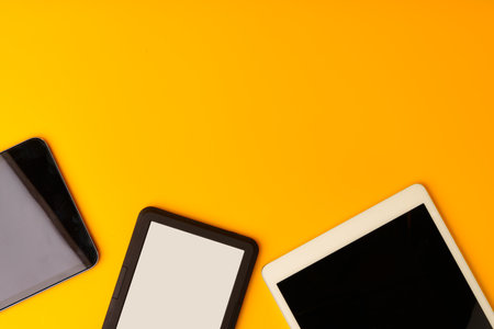 Digital tablet on yellow studio background top viewの写真素材