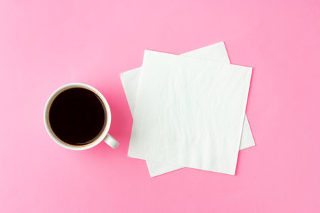 Coffee cup with paper napkins on pink backgroundの写真素材