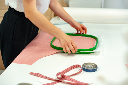 Seamstress working with fabric in sewing factory close up
