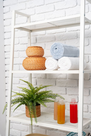 Rolled fluffy towels on shelf in bathroomの写真素材