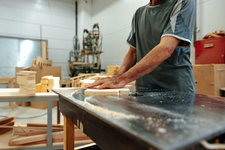 Close up of male carpenter working with piece of wood in a workshopの写真素材