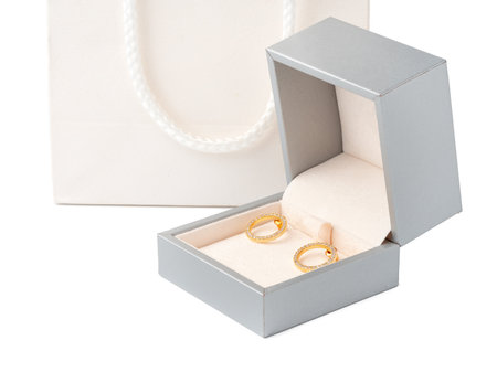 Golden earrings in jewelry box isolated on white backgroundの写真素材