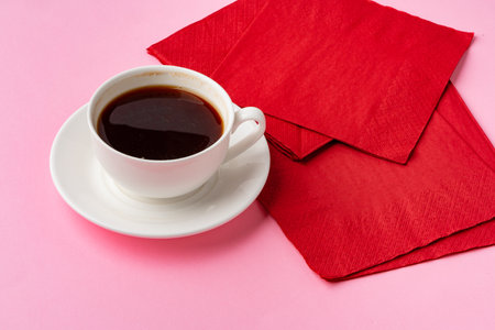 Coffee cup with paper napkins on pink backgroundの写真素材