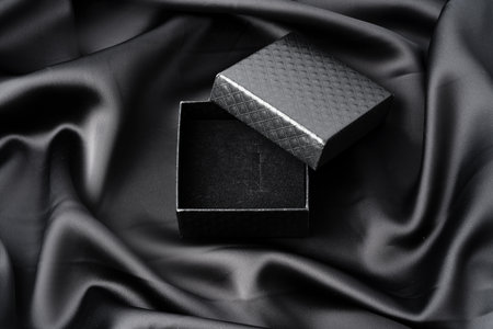 Empty jewelry box on silk background close up