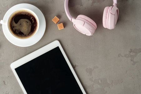 Digital tablet and coffee cup on gray background close upの写真素材