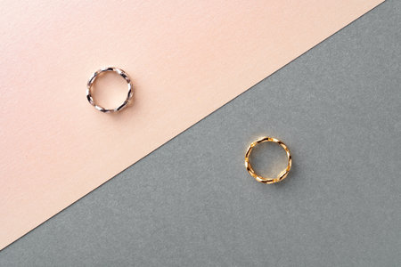 Two golden hoop earrings on paper background