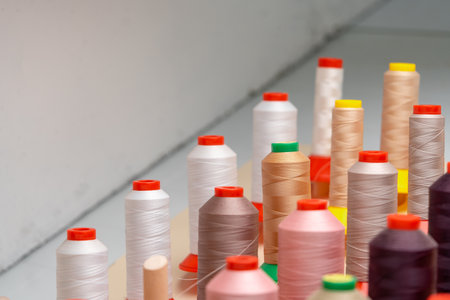 Row of multicolored thread spools at sewing factoryの写真素材