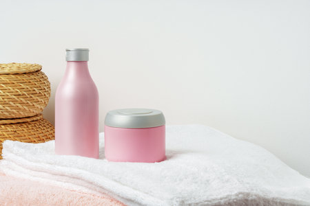 White cosmetics container mockup with towels on gray backgroundの写真素材