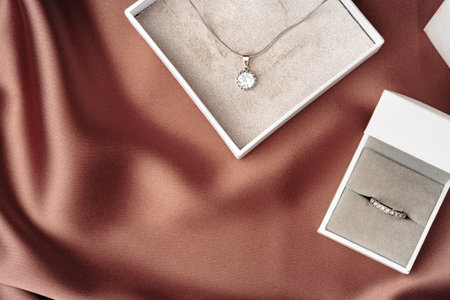 White jewelry boxes on brown silk backgroundの写真素材