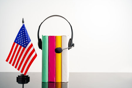 USA flag with pile of books against white backgroundの写真素材