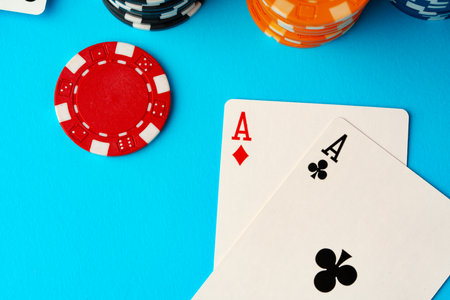 Playing cards and poker chips on blue background