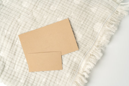 Warm cotton muslin blanket with paper tag on white background