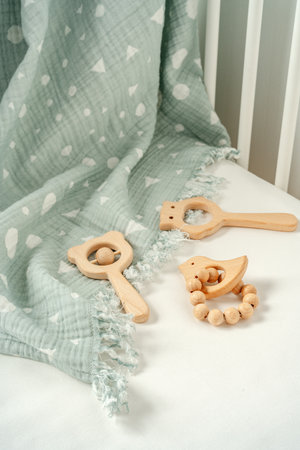Toys and muslin soft blanket in baby bed close upの写真素材