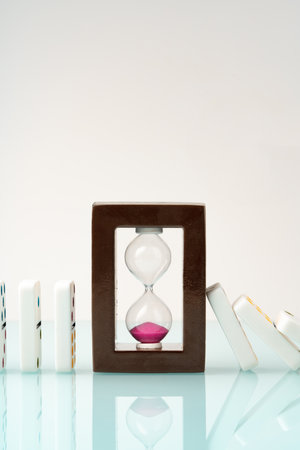 Hourglass and domino tiles on blue background. Time limit conceptの写真素材