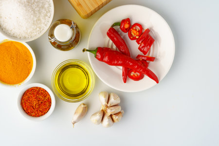 Bowls with spices and cooking ingredients on white backgroundの写真素材