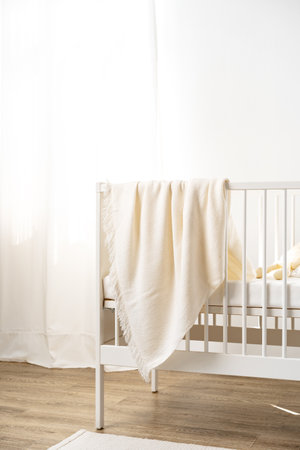 Muslin baby blanket hanging on childs bed in nursing roomの写真素材