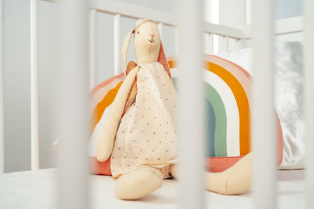 Wooden white baby crib and toy rabbit close upの写真素材