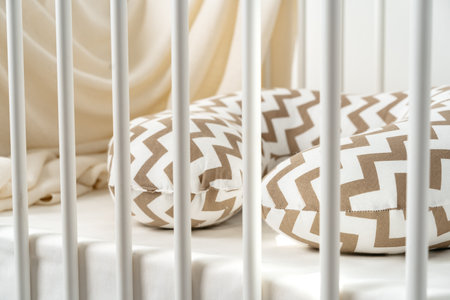 White wooden baby crib with pillow in nursery roomの写真素材