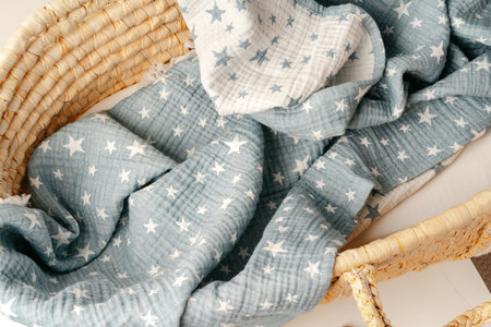 Baby cradle with muslin blanket and wooden toys in a baby roomの写真素材