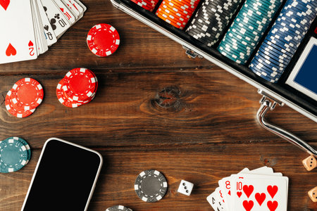 Poker chips and smartphone on wooden tableの写真素材