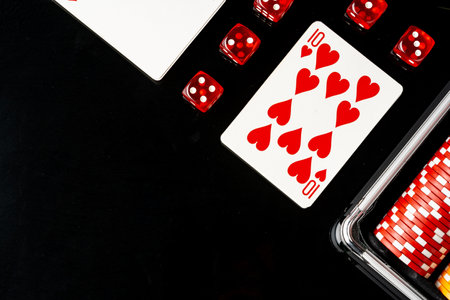 Playing cards and poker chips on black background