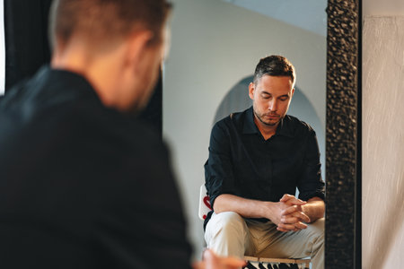Young man looking at himself in the mirrorの写真素材