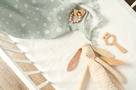 Toys and muslin soft blanket in baby bed close upの写真素材
