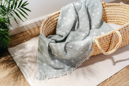 Baby cradle with muslin blanket and wooden toys in a baby roomの写真素材