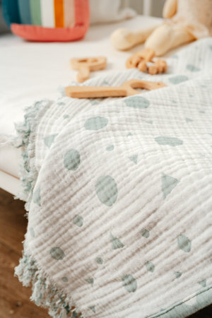 Toys and muslin soft blanket in baby bed close upの写真素材