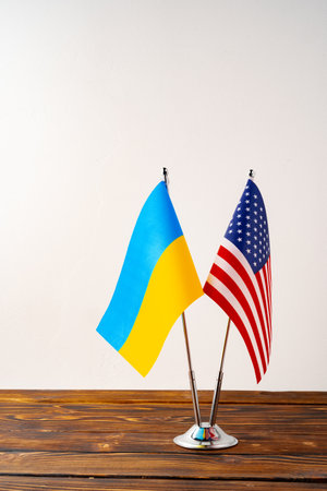 Small flags of USA and Ukraine on flagpoles close upの写真素材