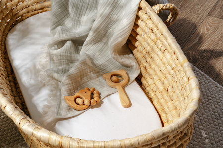 Muslin blanket and wooden toys in baby cradleの写真素材