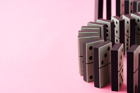Row of domino tiles on pink studio background