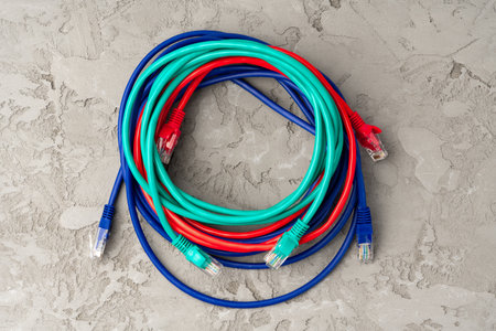 Colored network cable patch-cord on gray textured background