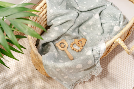 Muslin blanket and wooden toys in baby cradleの写真素材